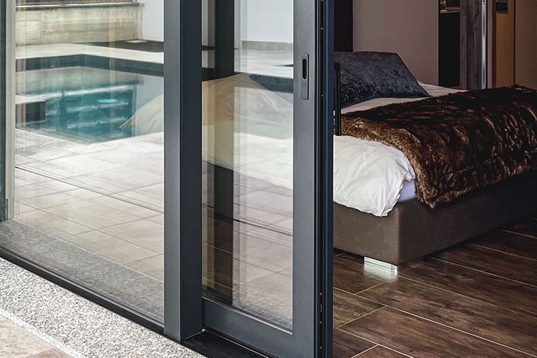 Camera da letto confortevole con porta finestra scorrevole che apre sulla piscina